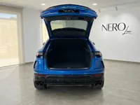 青いランボルギーニ ウルスが、イビサのショールーム内でトランクを開けた状態で後方から写されています。