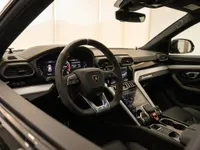 The luxurious interior of the Lamborghini Urus in Lausanne, showcasing the multi-function steering wheel and advanced digital dashboard.