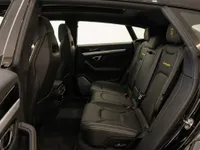 The luxurious black leather rear seats with yellow stitching and Lamborghini branding inside the 2020 Lamborghini Urus in Lausanne.