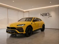 The 2021 Lamborghini Urus in Gloss Yellow, showcasing its dynamic front three-quarter view in a modern Lausanne showroom.