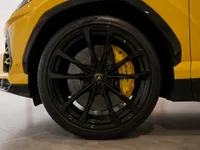 Close-up of the yellow Lamborghini Urus's front wheel, showcasing the black multi-spoke rim and vibrant yellow brake caliper in Lausanne.