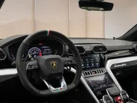 The luxurious interior of the Lamborghini Urus in Lausanne, showcasing the steering wheel, digital dashboard, and dual infotainment screens.