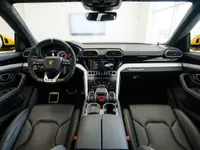 The luxurious black leather interior of the Lamborghini Urus in Lausanne, showcasing the dashboard, steering wheel, and front seats.