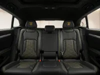 The luxurious black leather rear seats with yellow stitching and hexagonal pattern in the Lamborghini Urus interior in Lausanne.