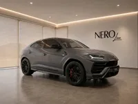 A grey Lamborghini Urus is parked in a modern showroom with the NEROline logo on the wall, Zurich.