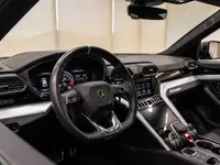 The luxurious interior of the Lamborghini Urus in Zurich, featuring its distinctive steering wheel, digital dashboard, and advanced center console.