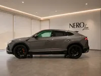 The grey 2021 Lamborghini Urus is parked in a modern showroom with the NEROline logo in Zurich.