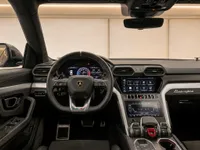 The luxurious interior of the Lamborghini Urus, showcasing the sophisticated cockpit, steering wheel, and dual digital displays in Zurich.