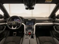 The luxurious cockpit of the Lamborghini Urus in Zurich, showcasing the steering wheel, digital dashboard, and central console with infotainment screens.