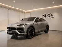 The silver Lamborghini Urus is showcased from a front three-quarter angle in a modern NEROline showroom in Zurich.