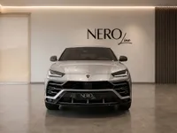 The silver Lamborghini Urus is prominently displayed in a luxury showroom in Zurich, showcasing its striking front design.