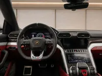 The luxurious interior of the Lamborghini Urus in Zurich, showing the steering wheel, dashboard, and infotainment screens.