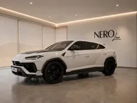 The white Lamborghini Urus Performante is parked indoors, showcasing its sleek front three-quarter view in Zurich.