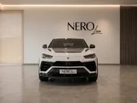 The white Lamborghini Urus Performante is showcased from the front, parked in a modern showroom with the NEROline logo in Zurich.