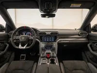 The luxurious interior cockpit and dashboard of the 2023 Lamborghini Urus Performante, featuring dual screens and a sporty steering wheel, available in Zurich.