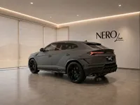 The black 2023 Lamborghini Urus Performante is showcased in a showroom with the NEROline logo on the wall in Zurich.