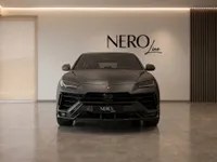 The black 2023 Lamborghini Urus Performante is showcased from the front in a modern NEROline showroom in Zurich.