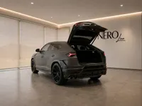 The black 2023 Lamborghini Urus Performante is parked in a showroom in Zurich, displaying its open trunk from a rear view.
