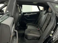 The luxurious black leather and Alcantara rear seats with orange stitching and Lamborghini logos are visible inside the Urus SE in Barcelona.