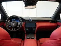 The luxurious interior of the Maserati GranCabrio in Lausanne, showcasing its vibrant red leather seats, modern dashboard, and central infotainment screen.