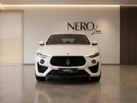 The white Maserati Levante Trofeo SUV is prominently displayed in a luxury showroom in Zurich, showcasing its distinctive front grille.