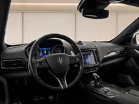 The luxurious black interior of the Maserati Levante Trofeo in Zurich, featuring its carbon fiber steering wheel and advanced dashboard.