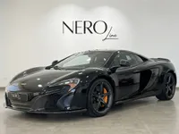 黒いマクラーレン650S MSOスーパーカーがマドリードのショールームに、前方3クォーターアングルで駐車されています。