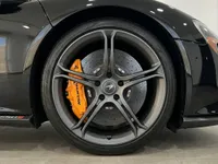 マドリードにあるマクラーレン650S MSOのフロントホイールの詳細。グレーのリム、カーボンセラミックブレーキ、鮮やかなオレンジのキャリパーが特徴です。