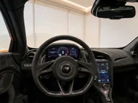 The luxurious cockpit of the McLaren 750S in Lausanne, featuring its carbon fiber steering wheel, digital displays, and Alcantara interior.