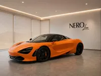A stunning gloss orange McLaren 750S Spider is elegantly displayed in a modern showroom in Zurich, featuring the NEROline logo.