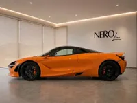 The orange McLaren 750S Spider is parked in a modern showroom with the NEROline logo visible on the wall in Zurich.