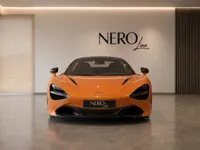 The vibrant orange McLaren 750S Spider is showcased head-on in a sleek, modern showroom featuring the NEROline logo.