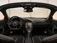 The luxurious interior of the McLaren 750S Spider in Zurich, featuring its advanced dashboard, ergonomic steering wheel, and comfortable black seats.