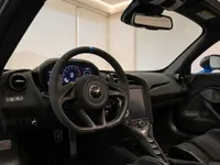 The luxurious cockpit of the McLaren 765LT Spider in Lausanne, featuring the Alcantara steering wheel, digital dashboard, and central console.