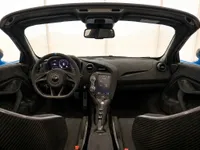 The luxurious interior of the McLaren 765LT Spider, featuring its dashboard, steering wheel, and carbon fiber seats, in Lausanne.
