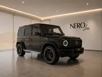 The glossy obsidian black 2022 Mercedes-AMG G 63 is parked indoors, showcasing its front three-quarter view in Zurich.