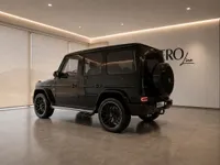 The black Mercedes-AMG G 63 is parked indoors, showcasing its rear three-quarter view in Zurich.