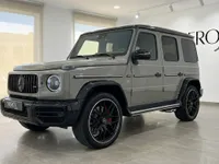 The gloss Arabian Grey Mercedes-Benz G63 AMG is seen from a front three-quarter angle, parked indoors in Ibiza.