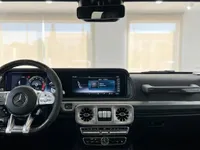 The luxurious cockpit of the 2020 Mercedes-Benz G63 AMG in Ibiza, featuring the steering wheel, digital dashboard, and infotainment screen.