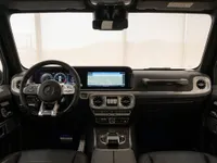 The luxurious interior of the Mercedes-Benz G63 AMG in Lausanne, featuring its advanced digital cockpit, multifunction steering wheel, and central infotainment display.