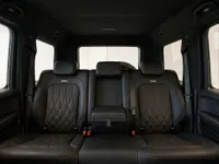 The luxurious rear seats of the Mercedes-Benz G63 AMG in Lausanne, featuring black leather with distinctive red diamond stitching.