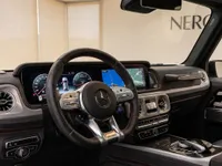 The luxurious interior of the Mercedes-Benz G63 AMG in Lausanne, featuring the steering wheel, digital dashboard, and infotainment screen.