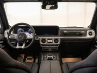 The luxurious cockpit of the Mercedes-Benz G63 AMG in Lausanne, featuring the dashboard, steering wheel, and infotainment screen.