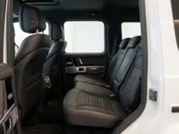 The luxurious black leather rear seats with red stitching and door panel of a Mercedes-Benz G63 AMG in Lausanne.