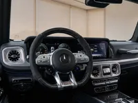 The luxurious cockpit of the Mercedes-Benz G63 Brabus in Lausanne, featuring the steering wheel, dashboard, and infotainment screen.