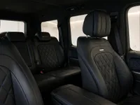 The luxurious interior of the Mercedes-Benz G63 in Lausanne, featuring black leather seats with blue stitching and diamond quilting.