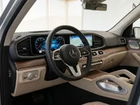 Mercedes-Benz GLE 350d cockpit in Lausanne, featuring the steering wheel, dual digital screens, and beige interior accents.