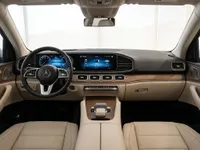 The luxurious interior cockpit of the Mercedes-Benz GLE 350d in Lausanne, featuring a modern dashboard, dual screens, and light beige leather seats.