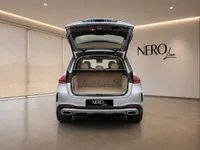 The rear view of a metallic silver Mercedes-Benz GLE 350d with its trunk open, showcasing ample cargo space in Lausanne.