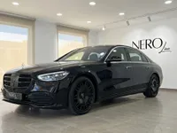 The gloss black Mercedes-Benz S 450 4MATIC is showcased in a showroom with large windows in Alicante, Spain.